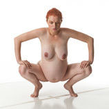 Nude pregnant art model squatting