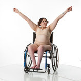Female art model with spina bifida posing in a wheelchair