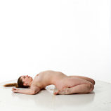 Artist reference photos of a nude curvy full figured female figure model posed laying on the floor