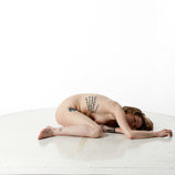 Artist reference photos of a slim nude blond female art model in a twisted pose