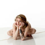 Artist reference photos of a slim nude blond female art model in a sitting pose