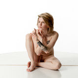 Artist reference photos of a slim nude blond female art model in a sitting pose