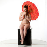 Artist reference photos of a nude curvy full figured female figure model posed sitting on a box